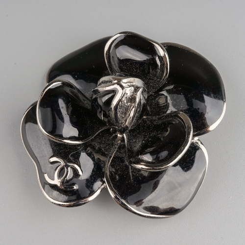 72 - Chanel - a black enamel flower brooch, interlocking C's, stamped to back 'Chanel Made in France 06',... 