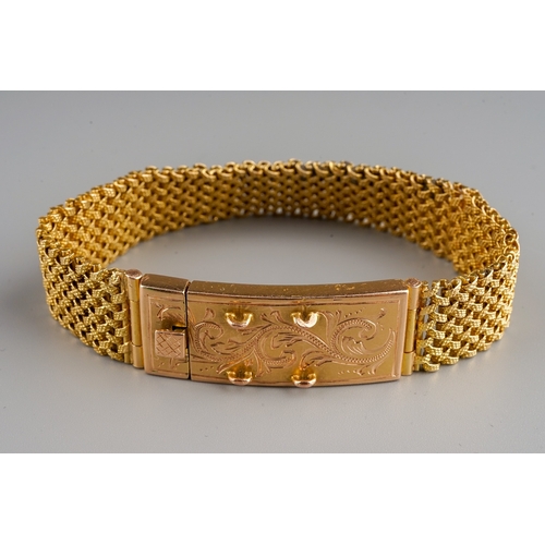 74 - A yellow gold bracelet, the textured mesh bracelet with large box clasp engraved with foliate swirls... 