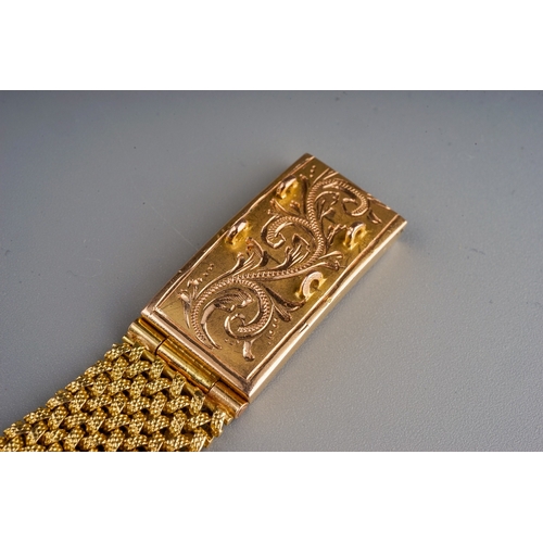 74 - A yellow gold bracelet, the textured mesh bracelet with large box clasp engraved with foliate swirls... 