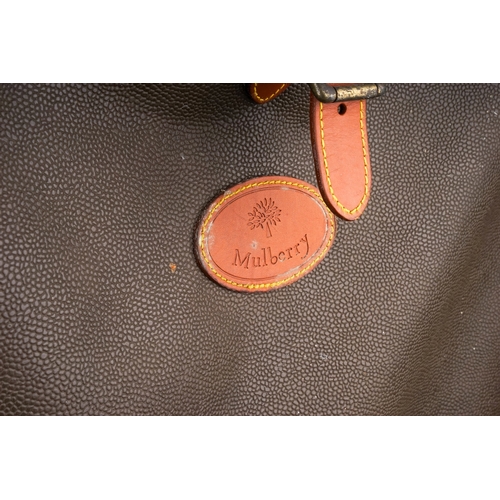 92 - A Mulberry style suitcase with green leather effect and tan leather trim outer, brass tag bears seri... 