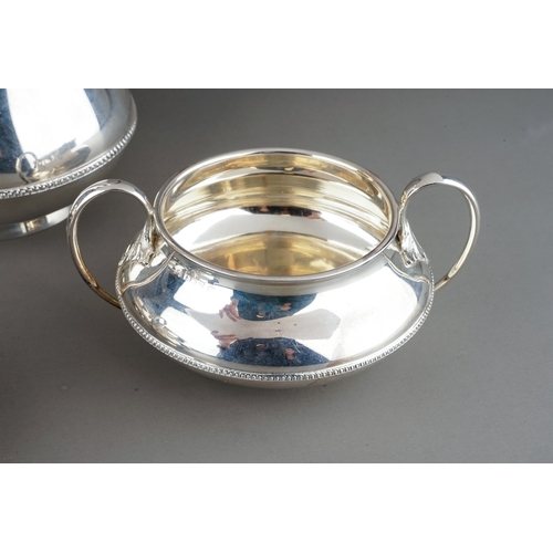 187 - A George V silver four piece tea service comprising teapot, sugar bowl, milk jug and hotwater jug, p... 