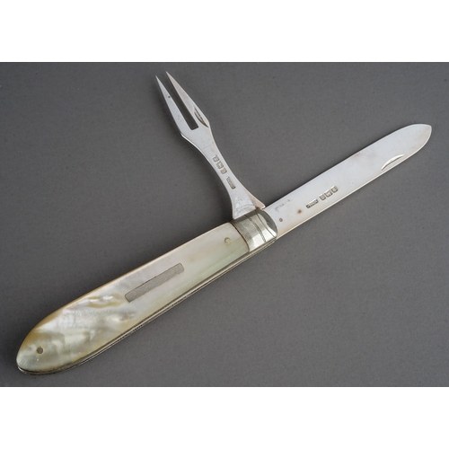 194 - A George V silver and mother-of-pearl combination fruit knife and fork, pivot action, vacant cartouc... 