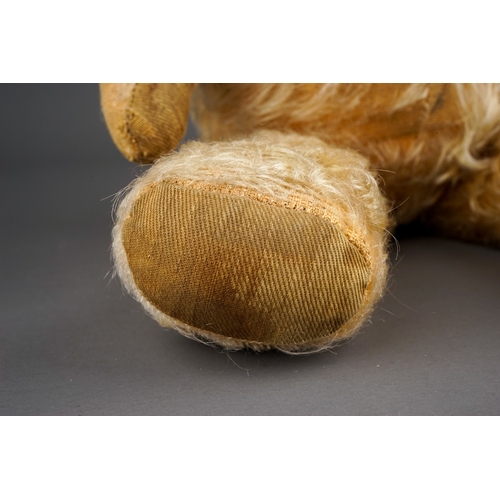 305 - An early 20th Century straw filled Bear with glass eyes, black snout, articulated arms, blonde mohai... 