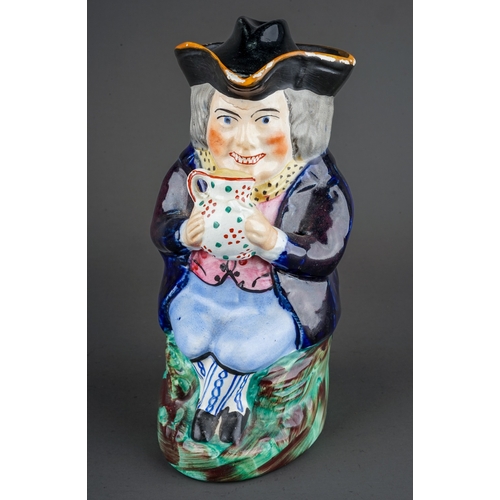 330 - A 19th Century character jug and cover moulded as a seated Gentleman drinking from a beer jug with t... 