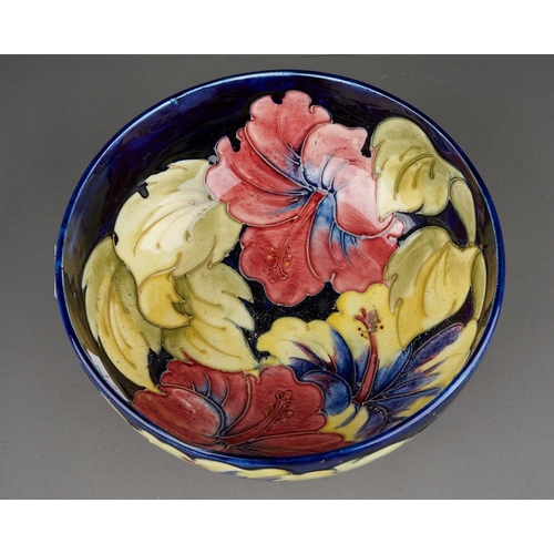 347 - Moorcroft bowl in Hibiscus pattern on a dark blue ground  by William Moorcroft, signed to base in gr... 