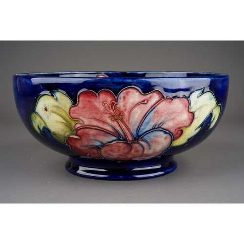 347 - Moorcroft bowl in Hibiscus pattern on a dark blue ground  by William Moorcroft, signed to base in gr... 