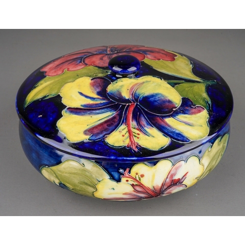 348 - Moorcroft dish and cover in Hibiscus pattern on a dark blue ground  by William Moorcroft, stamped an... 