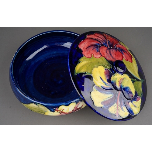 348 - Moorcroft dish and cover in Hibiscus pattern on a dark blue ground  by William Moorcroft, stamped an... 