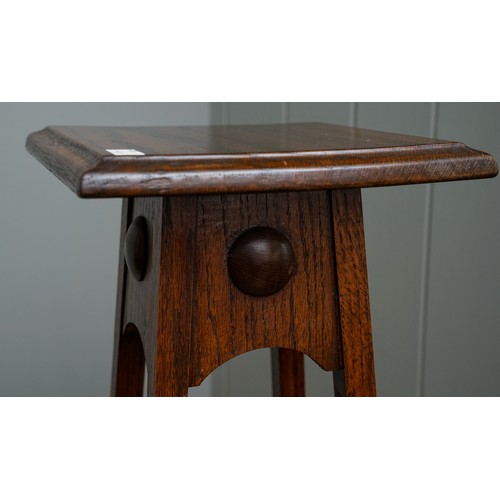 402 - An Arts & Crafts Liberty style oak jardiniere stand, plain body above tapering supports, the upper s... 