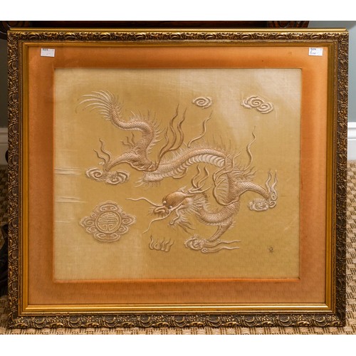 478 - A Chinese embroidered cream silk panel depicting a four claw dragon, clouds to the skyline and sun t... 