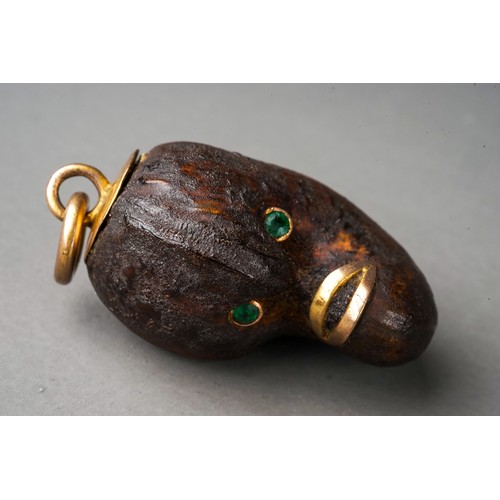 567 - Tagua nut ? Lucky bean charm with green stone eyes and high carat gold mounts, circa 1900