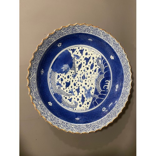 476A - An Asian probably Japanese blue and white charger, wavy rim with water motif border, the centre pain... 