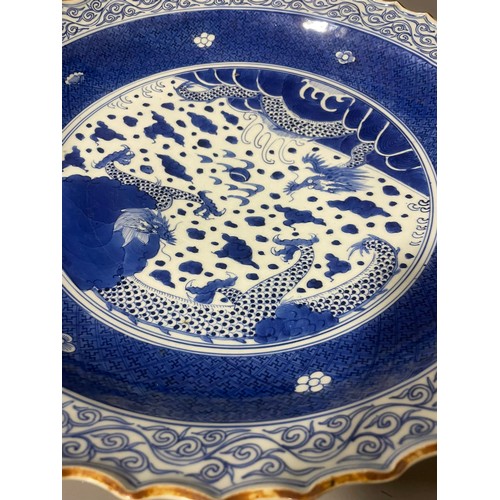 476A - An Asian probably Japanese blue and white charger, wavy rim with water motif border, the centre pain... 