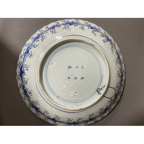 476A - An Asian probably Japanese blue and white charger, wavy rim with water motif border, the centre pain... 