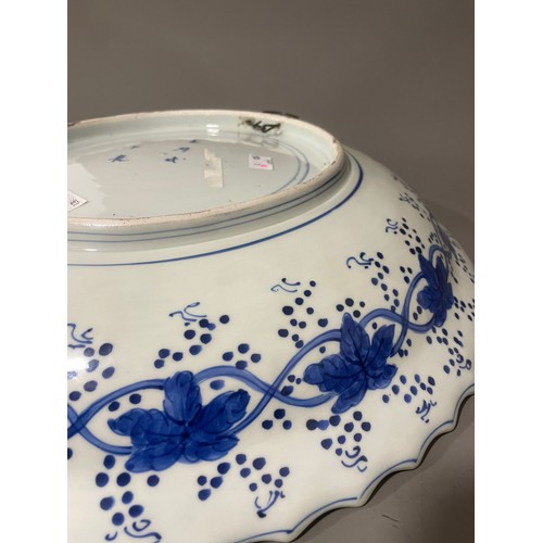 476A - An Asian probably Japanese blue and white charger, wavy rim with water motif border, the centre pain... 