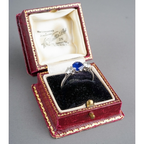 28 - A sapphire and diamond three-stone ring, set with a mixed-cut sapphire flanked by two round brillian... 