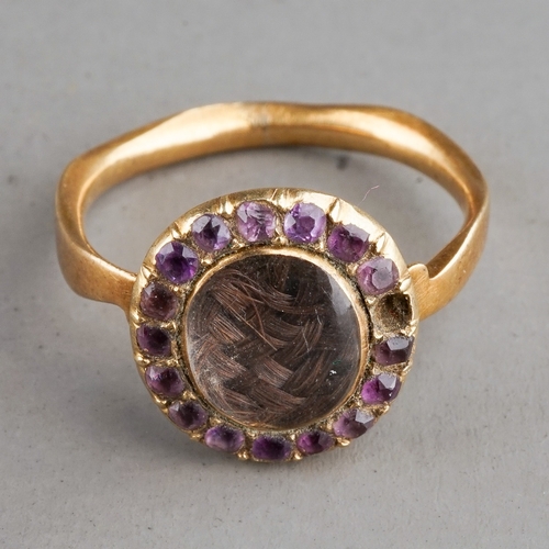 35 - A 19th century yellow metal oval mourning ring, centred with a plait of hair under glazed, within a ... 