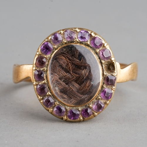 35 - A 19th century yellow metal oval mourning ring, centred with a plait of hair under glazed, within a ... 