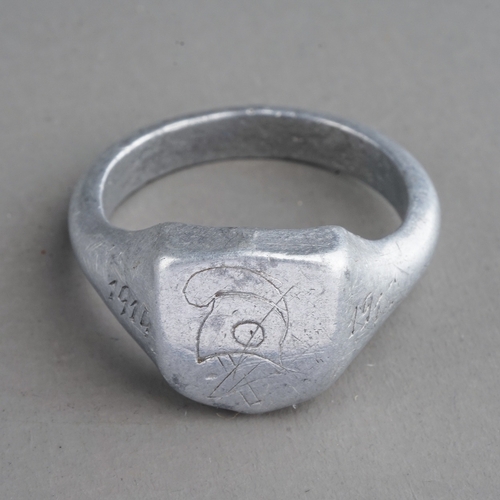 36 - A French WWI Patriotic Trench Art ring, made in alloy with Cavalry helmet motif flanked by dates 191... 