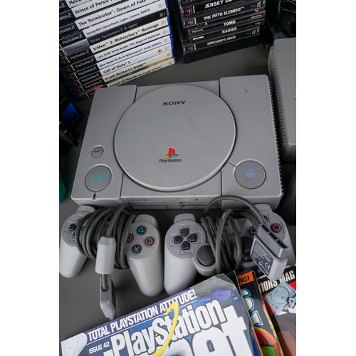 106 - Two Sony PlayStation 1s and a Sony Playstation 2 game consoles with five controllers together with a... 