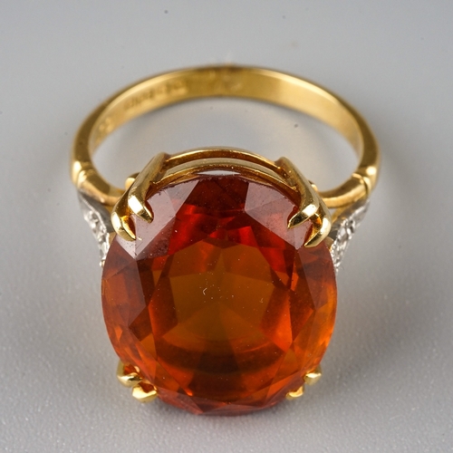 230 - An 18ct yellow gold citrine and diamond dress ring, set with an oval cut citrine in claw settings, d... 