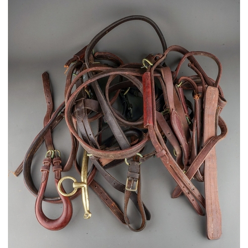 575 - A box containing a quantity of brown leather and brass horse tack, including harnesses, bridle and a... 