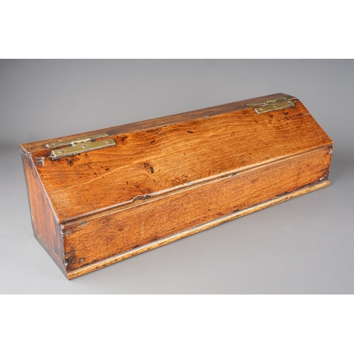 576 - An early 19th century oak and stained pine candle box of rectangular form with sloped hinged lid and... 