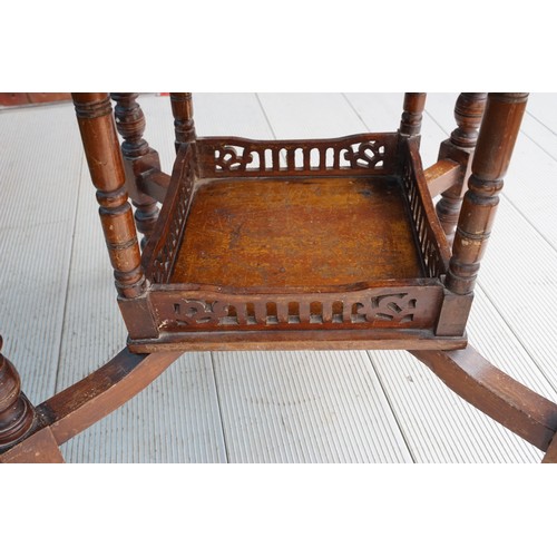 596 - An early 20th Century mahogany occasional table, on turned supports with central tier shelf section,... 