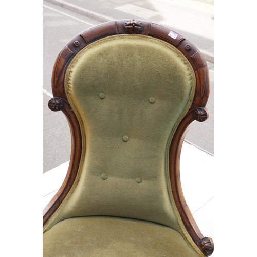 597 - A Victorian mahogany balloon back easy chair, the carved back rail with five raised floral decorativ... 