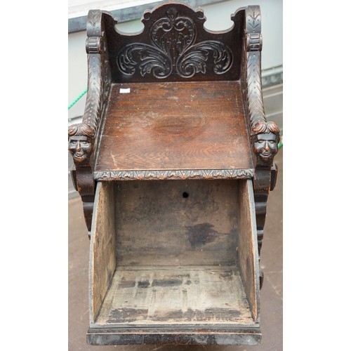 598 - A Victorian Gothic oak combination hall seat and coal skuttle, the fall front carved with Lion`s hea... 