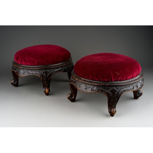 619 - A pair of late Victorian circular walnut footstools, red velvet upholstered inset tops, foliate carv... 