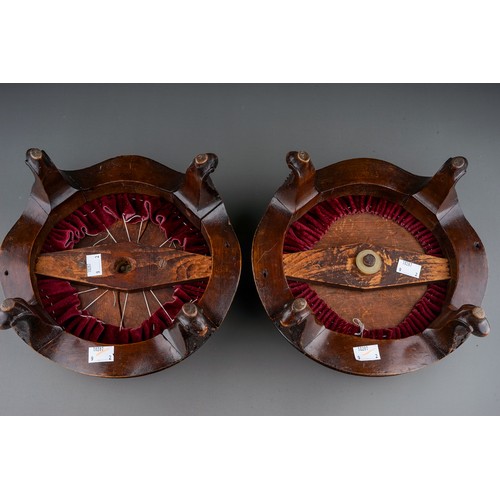 619 - A pair of late Victorian circular walnut footstools, red velvet upholstered inset tops, foliate carv... 