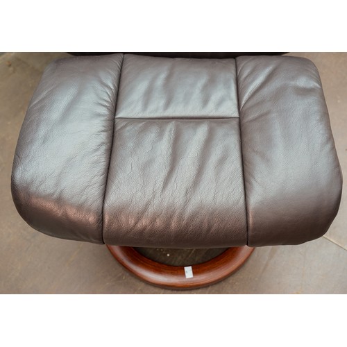 623 - A Stressless brown leather upholstered reclining armchair with matching stool, marked Stressless to ... 