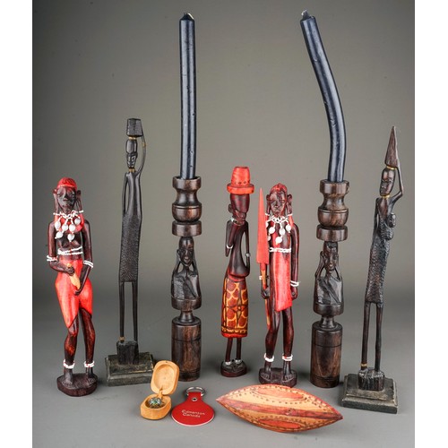 131A - A collection of seven late 20th century tribal figures, including a pair of candlesticks carved with... 