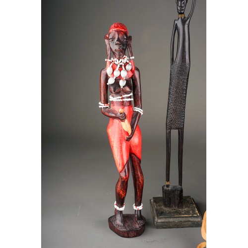 131A - A collection of seven late 20th century tribal figures, including a pair of candlesticks carved with... 