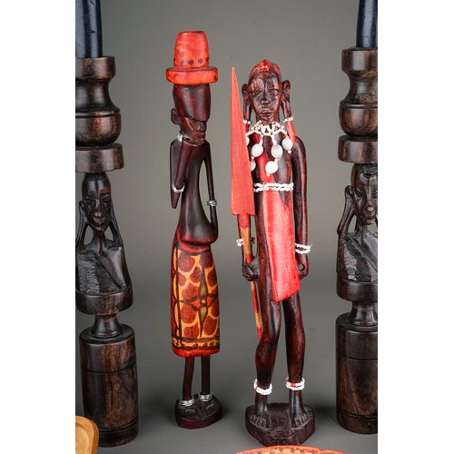 131A - A collection of seven late 20th century tribal figures, including a pair of candlesticks carved with... 