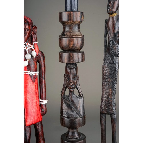 131A - A collection of seven late 20th century tribal figures, including a pair of candlesticks carved with... 