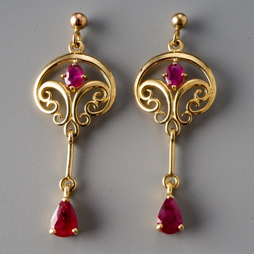 8 - A pair of 9ct yellow gold and ruby drop earrings, the scrolling openwork suspending a knife-edge dro... 