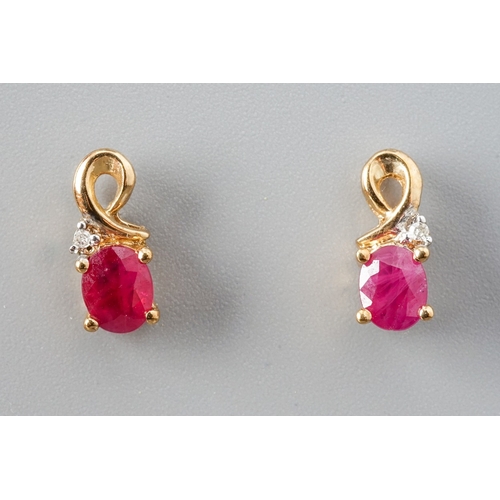 9 - A pair of 9ct yellow gold ruby and diamond stud earrings, set with oval mixed-cut rubies and a small... 