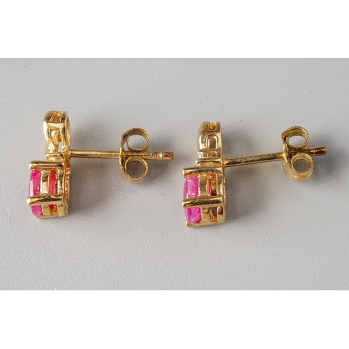 9 - A pair of 9ct yellow gold ruby and diamond stud earrings, set with oval mixed-cut rubies and a small... 