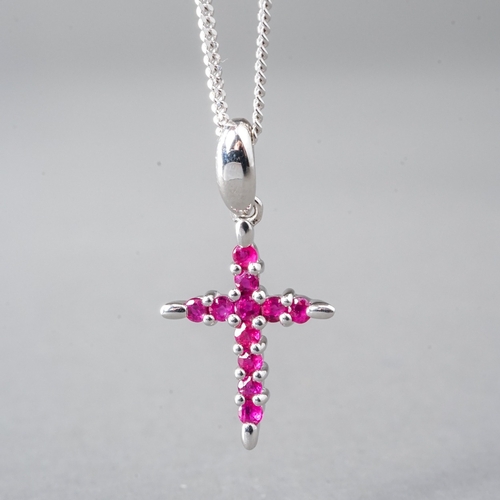 11 - A 9ct white gold and ruby crucifix pendant necklace, set with round-cut rubies, approx 18mm, on a fi... 