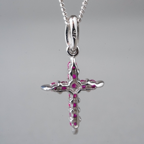 11 - A 9ct white gold and ruby crucifix pendant necklace, set with round-cut rubies, approx 18mm, on a fi... 