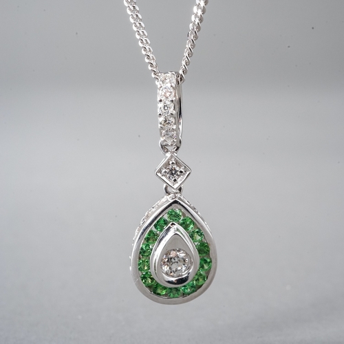 16 - An 18ct white gold diamond and green stone pear shape pendant, set with round brilliant-cut diamonds... 