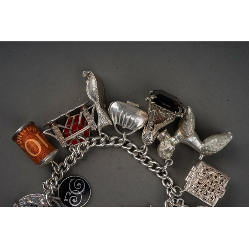 130 - Sterling silver charm bracelet with 18 charms  gross weight 129g.