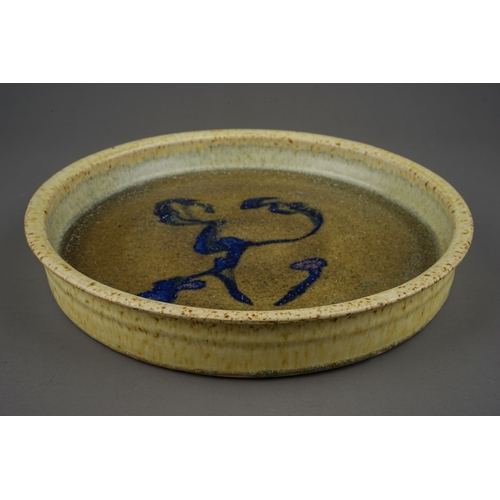 432 - A studio pottery circular shallow dish in manner of Mingei, the green glaze with abstract blue desig... 