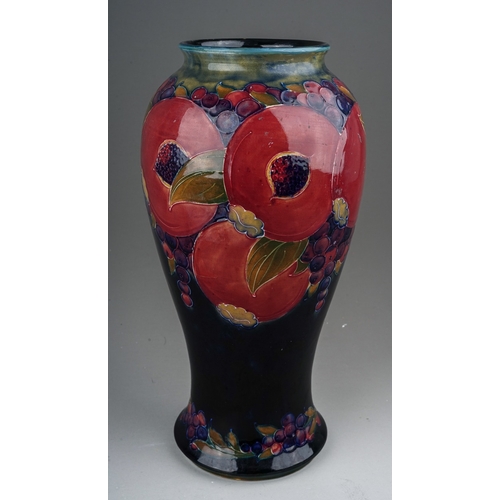 435 - A William Moorcroft Pomegranate pattern baluster vase, blue ground, restoration to upper rim, green ... 