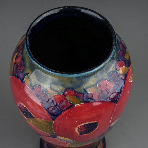 435 - A William Moorcroft Pomegranate pattern baluster vase, blue ground, restoration to upper rim, green ... 