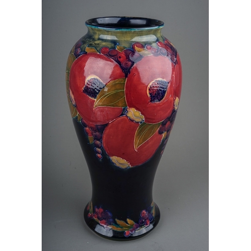 435 - A William Moorcroft Pomegranate pattern baluster vase, blue ground, restoration to upper rim, green ... 