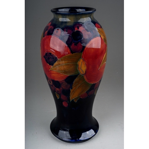 436 - A William Moorcroft Pomegranate pattern baluster vase with flared foot rim, blue ground, green signa... 