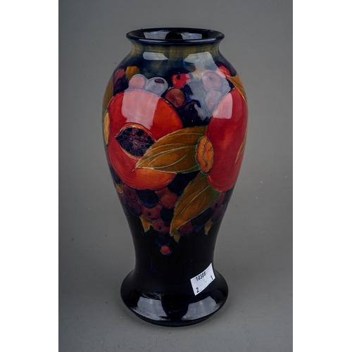 436 - A William Moorcroft Pomegranate pattern baluster vase with flared foot rim, blue ground, green signa... 